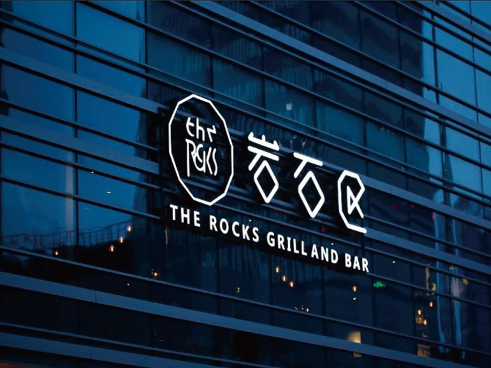 A neon sign crafted by a renowned signboard maker in Singapore, featuring the words "Together Forever" in pink cursive letters and a heart symbol, is beautifully mounted on a dark wall.